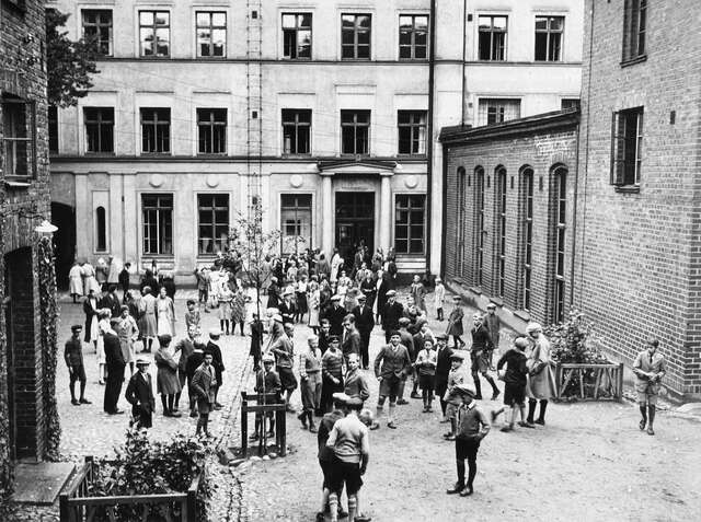 A courtyard of a school, pupils standing and playing