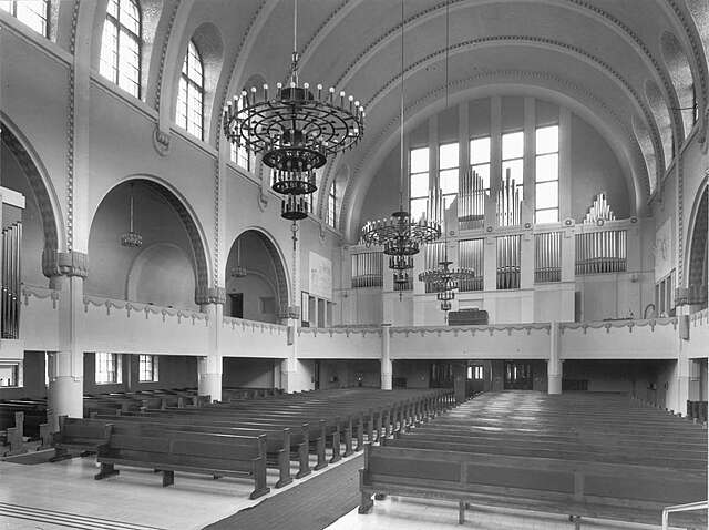 Interior view with church benches, ceiling lights and organ.