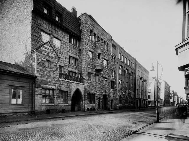 Stone facade with a bay window and arch details.
