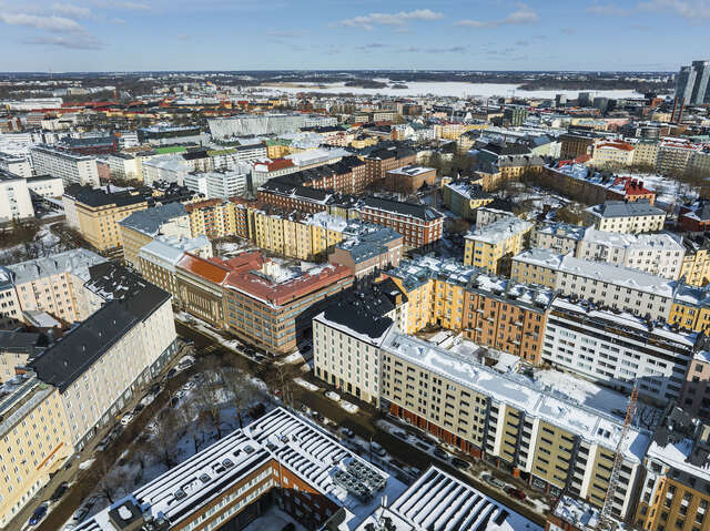 An aerial view of a large city, with multiple blocks of stone apartment buildings of different colors and styles