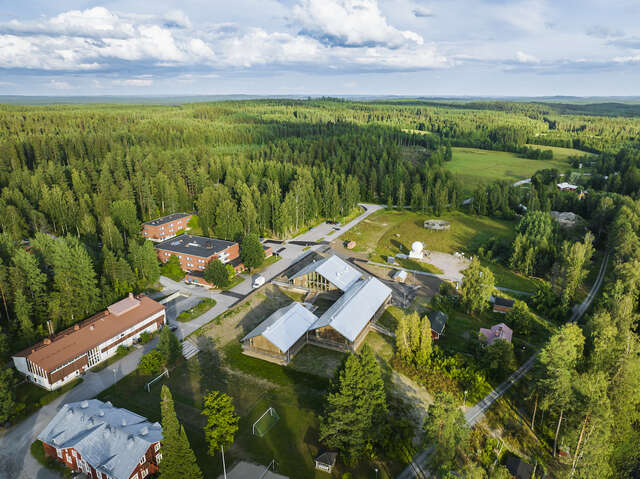 An aerial view of a building in the middle of a forest.