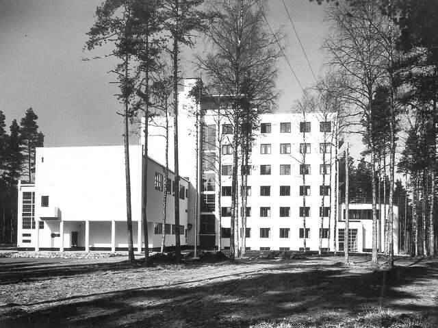 Multiple story building with a plain white facade with square windows.