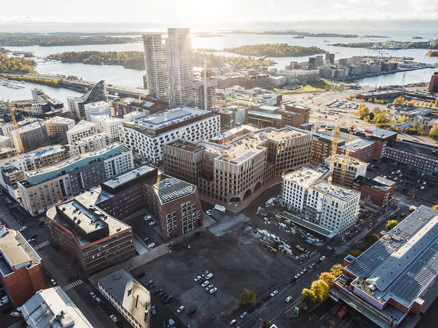 Aerial photo of a new, developing city district, two high towers and open sea in the background