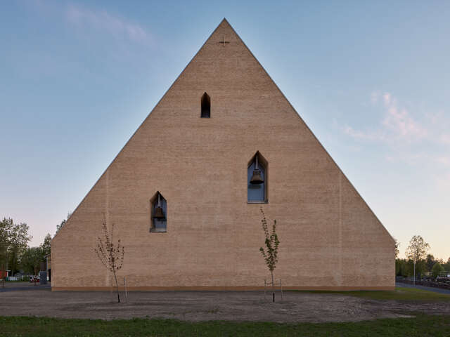 A triangular stone building with scattered windows.