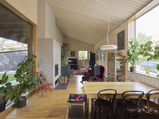 A large room, lit by a window to the right. A table and chairs can be seen in the foreground