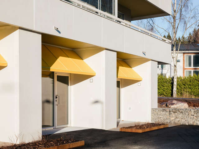 Ground floor of an apartment building with yellow sun shades