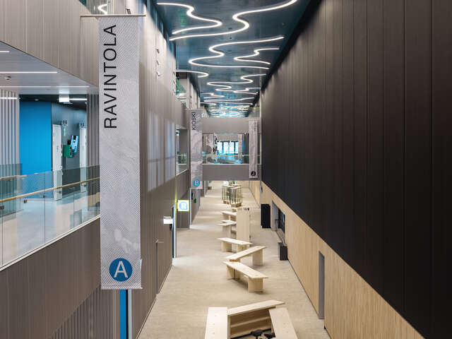 A large indoor two-story corridor, with a seating area on the ground floor.