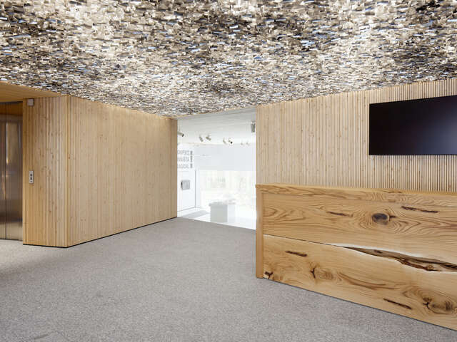 Gallery interior with granite floor and rock ceiling with wooden elements separating space