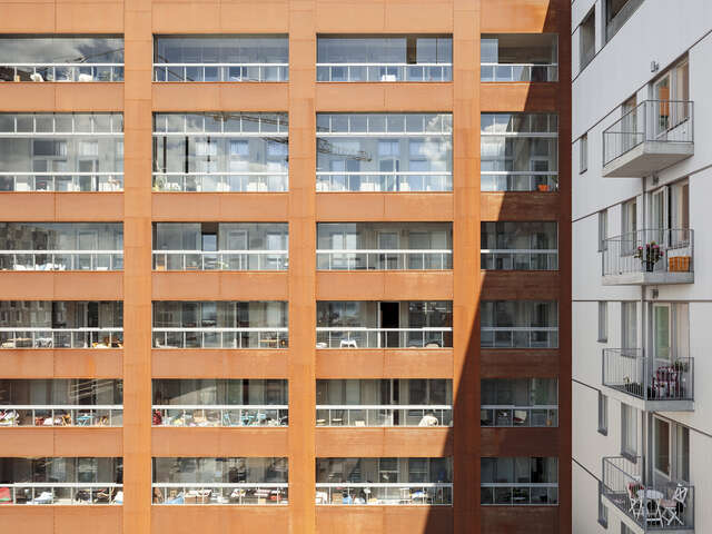 Wooden and white apartment buildings at an right angle.