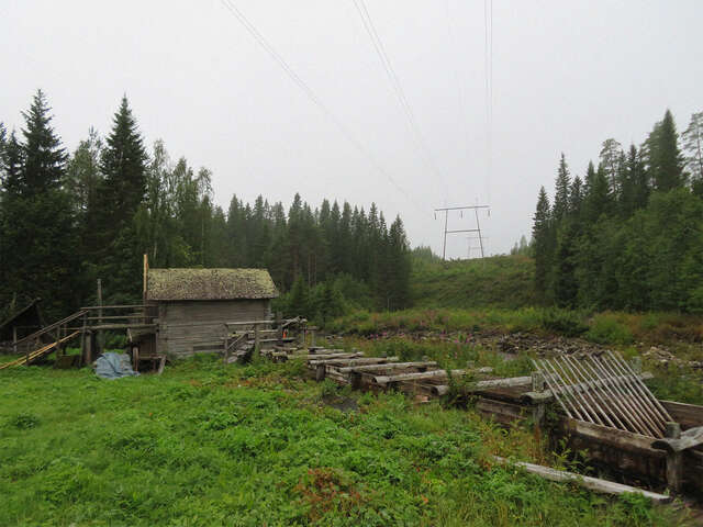 Picture of a cabin in a forest landscape.