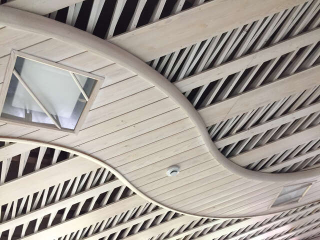 Wooden ceiling detail with slim bars crossing each other.