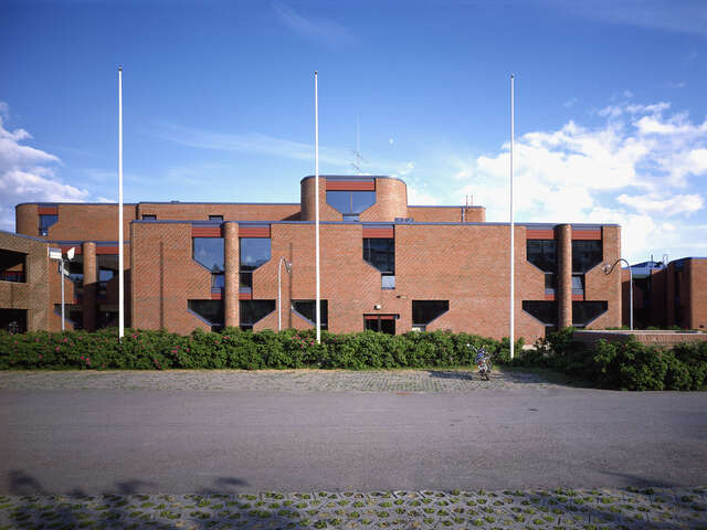 Red brick building with rounded corners.