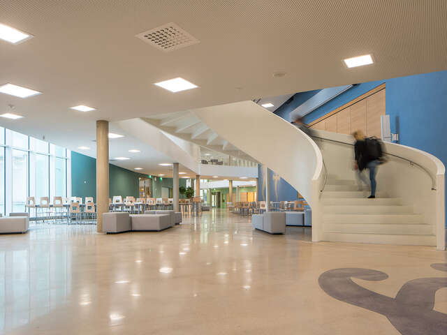White spiral stairs at the right, the canteen at the left in the back.