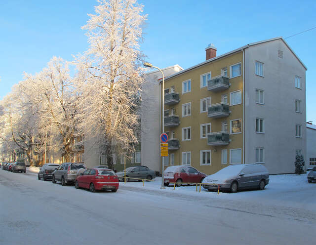 Offset row of identical but different colored apartment buildings in a sunny winter day.
