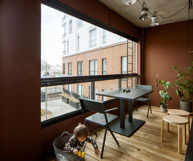 Glass covered balcony with lights, a sitting area and houseplants.