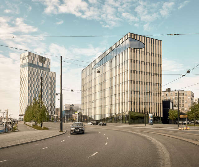 A large wooden building as seen from the street. Second large building on the left.