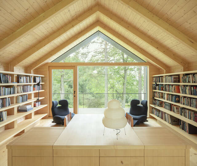 A room in a wooden building with bookshelves and chairs