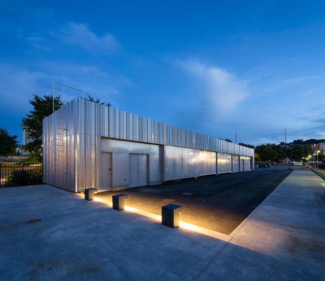 Container shaped building with textured metal walls.