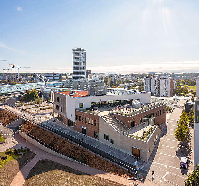 A three-story school building nearby a metro station photographed with a drone.