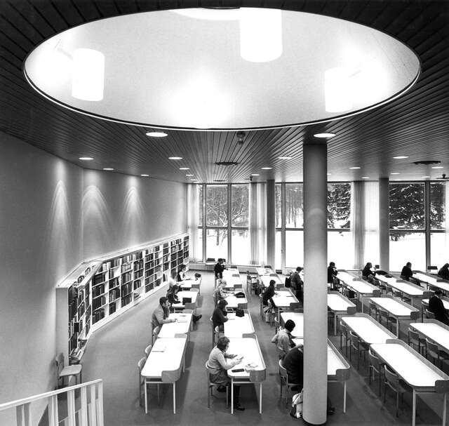 large hall with a round ceiling windows and many rows of white tables.