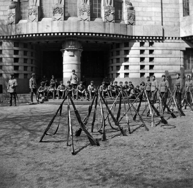 Soldiers sitting on the steps of the building.