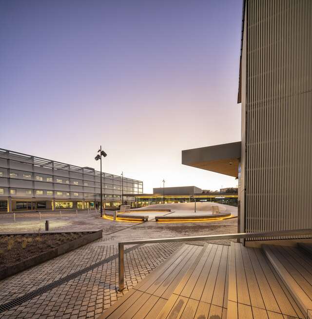 A view of a paved square as seen atop some stairs.