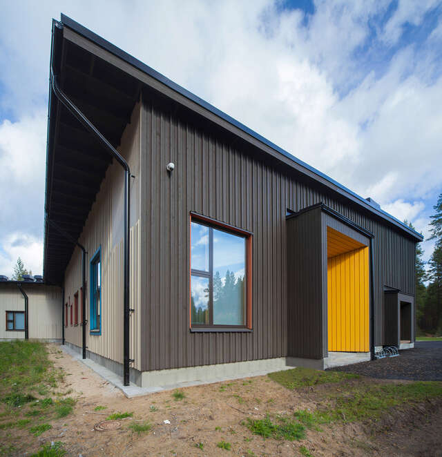 Wooden facade with colorful window and door frames.