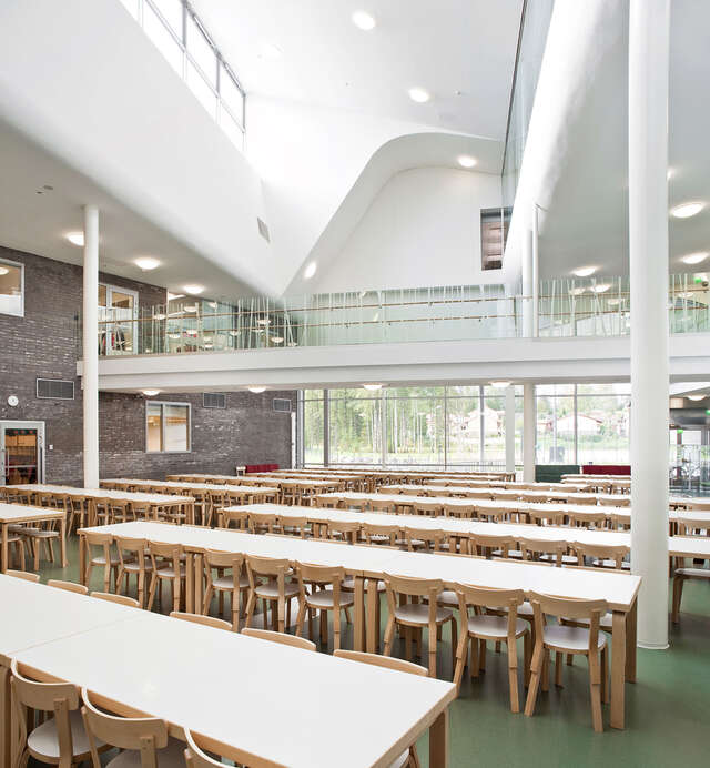 Spacious canteen with white, brick, and wooden details.