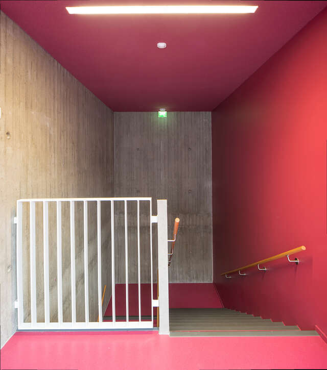Stairway with concrete and pink walls.