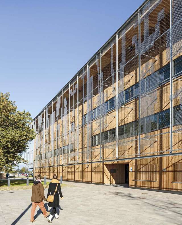 Two people walking towards the main entrance.