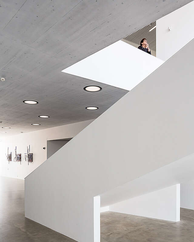 White interior with concrete floors and clean white lines.