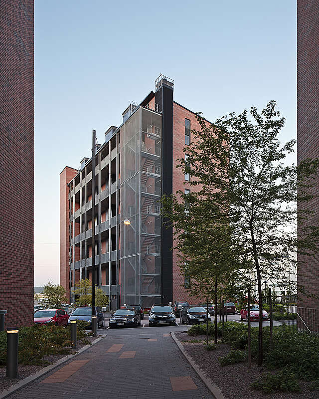 Building viewed from the side with a glass walls around the stairway at the corner of the building.