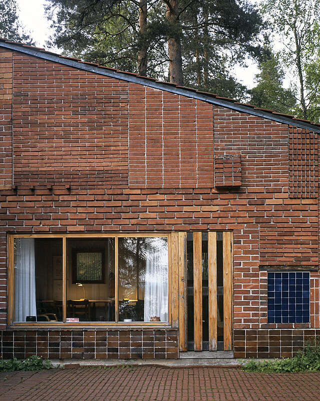 Brick house with a slanted roof and wood-framed windows