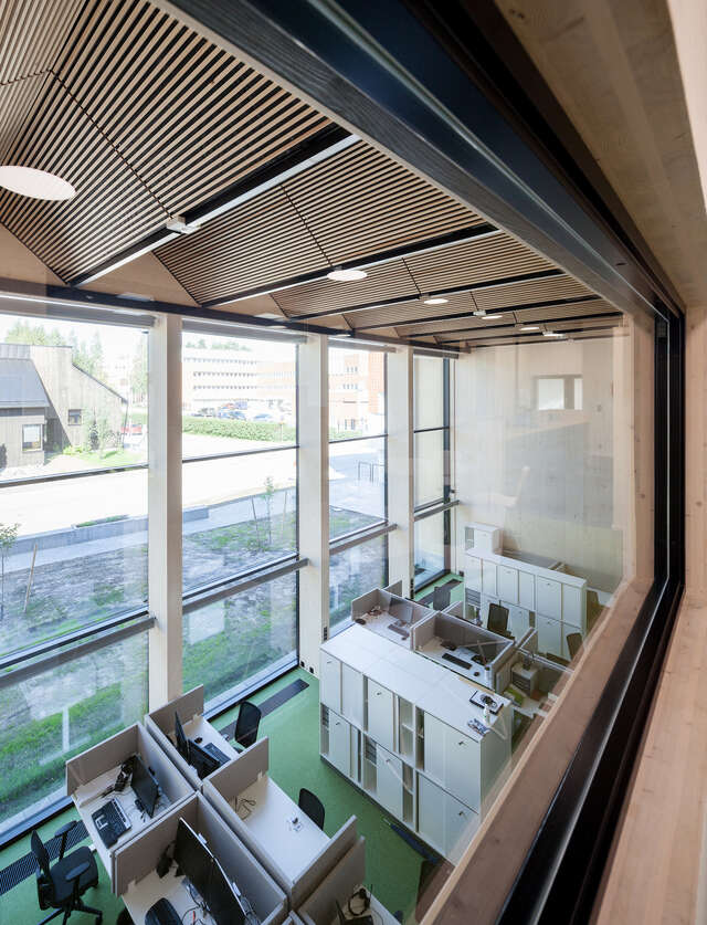 A room with computer stations and cabinets, with large windows looking out