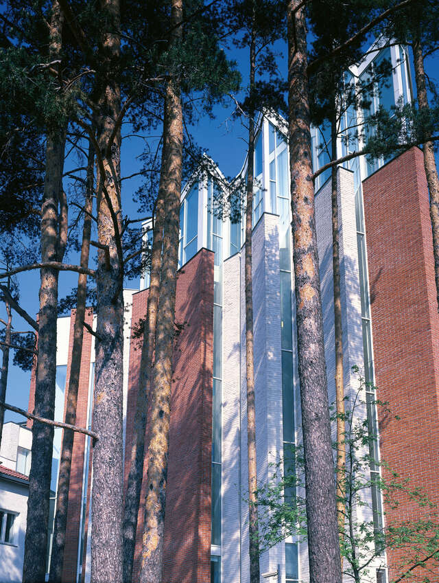 Red and white brick facade with windows at the top .