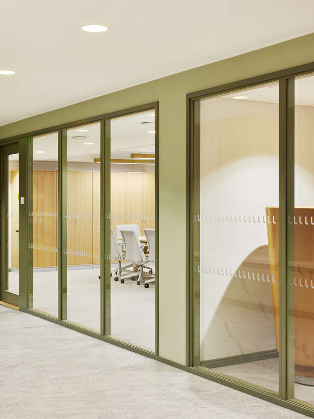 Interior of a building with glass interior walls showcasing meeting rooms.