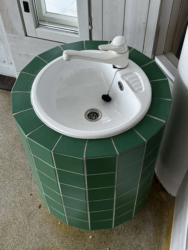 A sink covered in green tiles