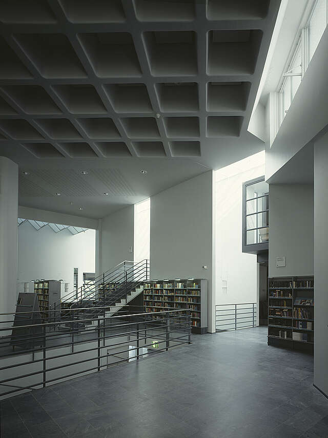 Bookshelves next to stairs with a metal railing.
