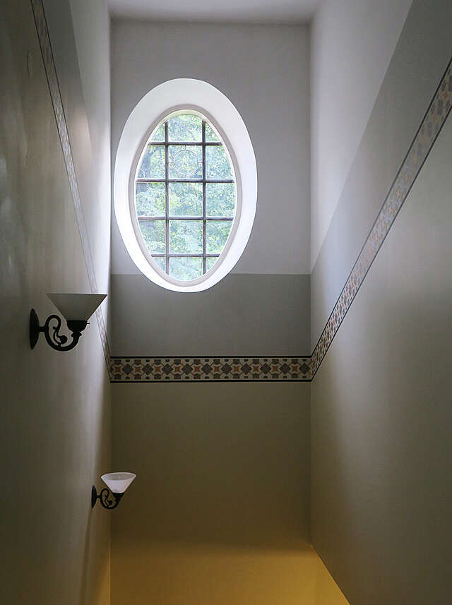 Oval window and wall painting of the staircase.