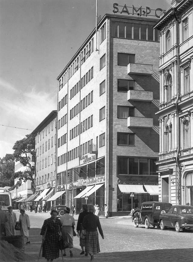 Black and white picture of modern multiple storey brick building with small balconies.