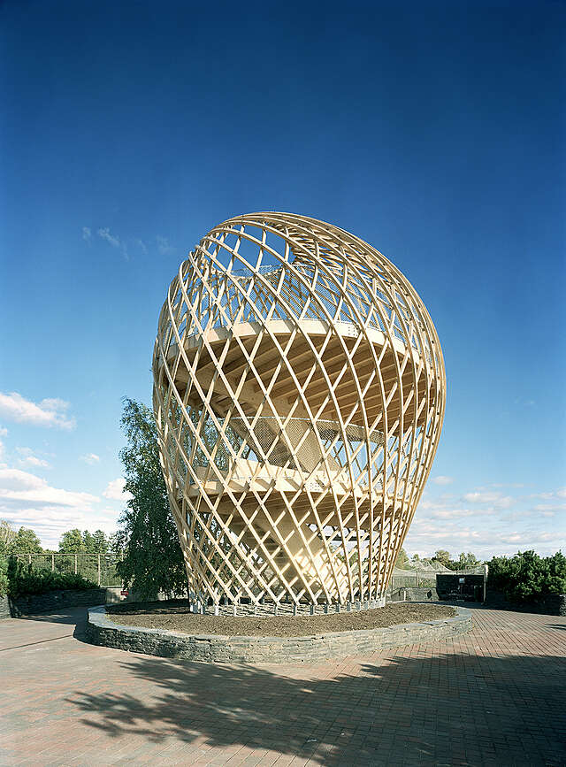Wood sculptural observation tower with a grid detail on a sunny day.