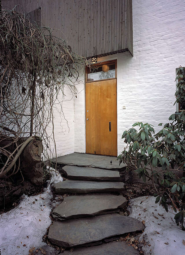 Low rock stairs leading to the wooden front door