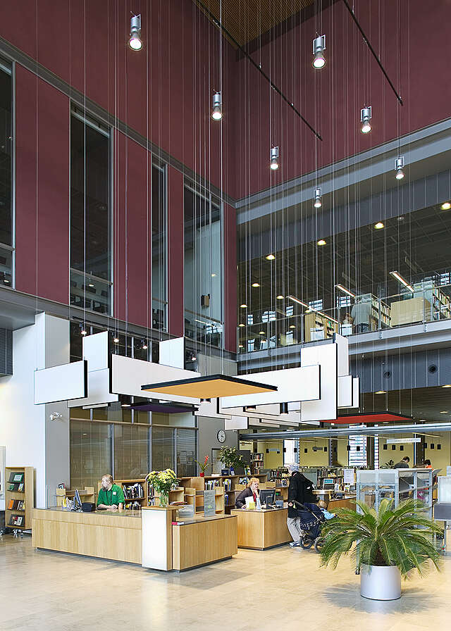 Library information desk with purple and glass walls able it.