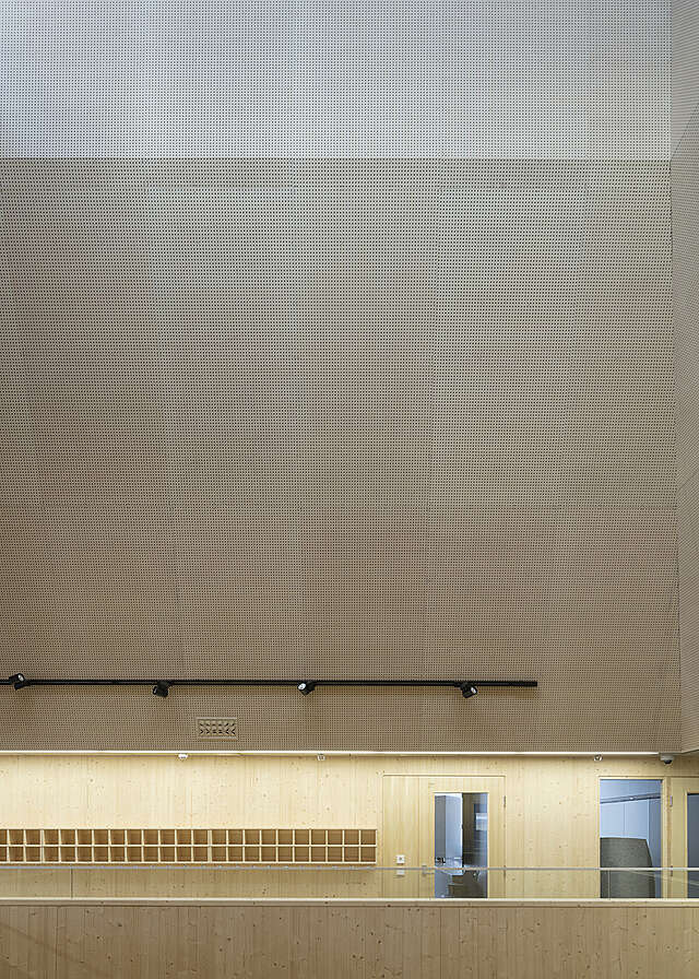 The ceiling in made of wide panels with small holes on them.