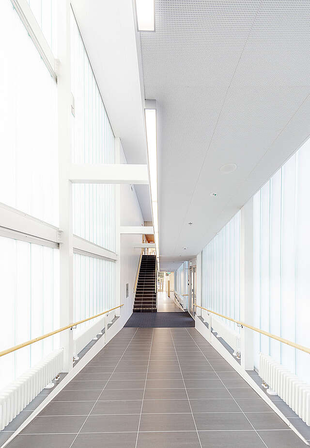 White hallway with many windows.