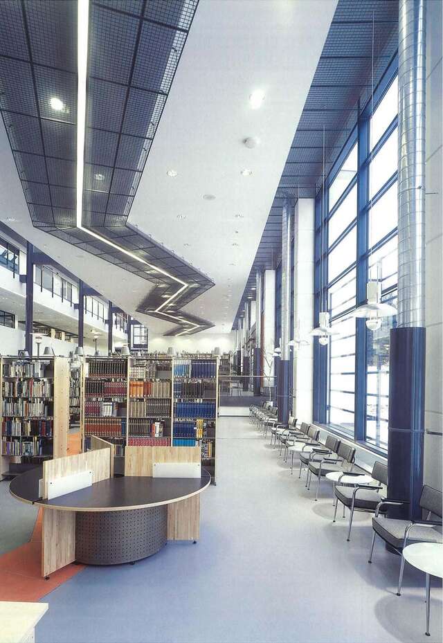 Loan section of a library with glass wall and shelves.