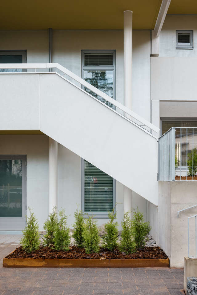 Wall of an apartment building with a small staircase and windows