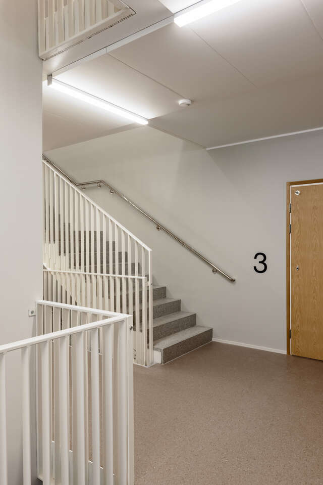 A stairwell of an apartment building with white walls