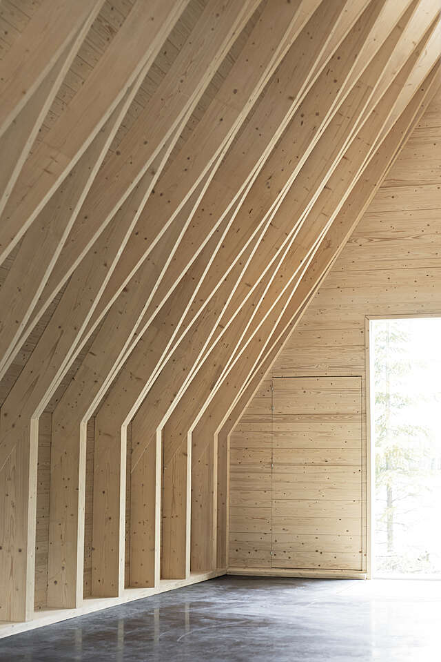 Detail of an interior space, wood-coloured walls and trusses