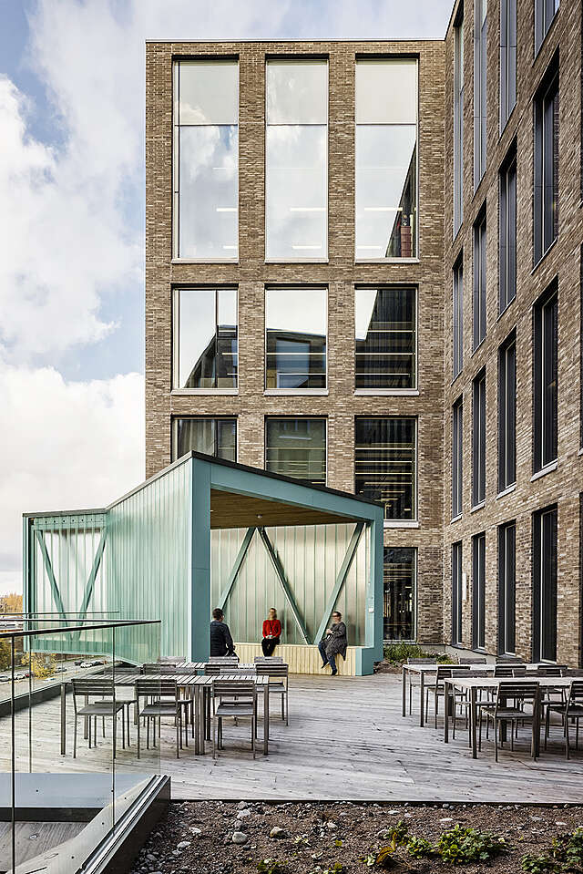 Green metal structure glazed pavilion on a roof terrace